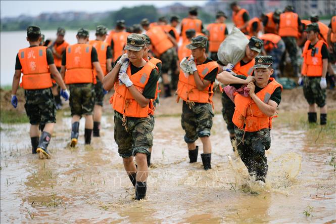Trong ảnh: Binh sĩ Trung Quốc được tăng cường hỗ trợ người dân hộ đê ngăn lũ tại huyện Bà Dương, tỉnh Giang Tây ngày 12/7/2020. Ảnh: THX/TTXVN