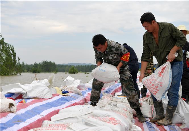 Trong ảnh: Binh sĩ Trung Quốc được tăng cường hỗ trợ người dân hộ đê ngăn lũ tại Cửu Giang, tỉnh Giang Tây ngày 12/7/2020. Ảnh: THX/TTXVN