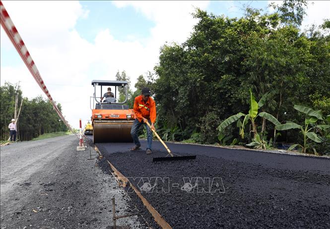 Trong ảnh: Tranh thủ thời tiết nắng ráo, các nhà thầu đang đẩy nhanh tiến độ thi công trải thảm mặt đường. Ảnh: Huy Hùng - TTXVN