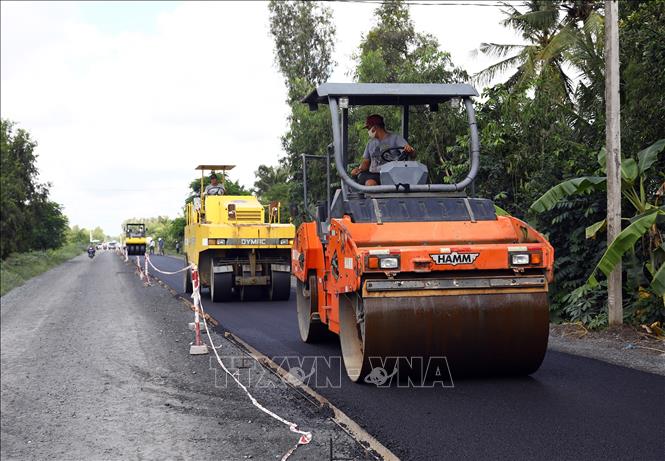 Trong ảnh: Lu lèn lớp bê tông nhựa đường. Ảnh: Huy Hùng - TTXVN
