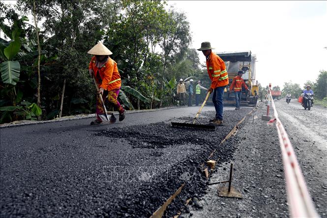Trong ảnh: Tranh thủ thời tiết nắng ráo, các nhà thầu đang đẩy nhanh tiến độ thi công trải thảm mặt đường. Ảnh: Huy Hùng - TTXVN