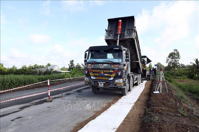 Trong ảnh: Trải thảm nhựa mặt đường tại gói thầu số 2. Ảnh: Huy Hùng - TTXVN
