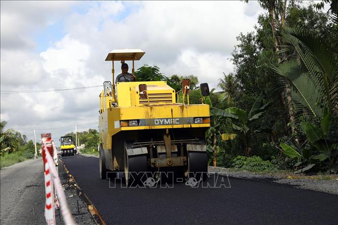 Trong ảnh: Trải thảm nhựa mặt đường tại gói thầu số 2. Ảnh: Huy Hùng - TTXVN