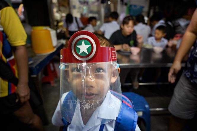 Trong ảnh: Một học sinh đeo tấm chắn nhựa phòng lây nhiễm COVID-19 tại Bangkok, Thái Lan. Ảnh: AFP/TTXVN