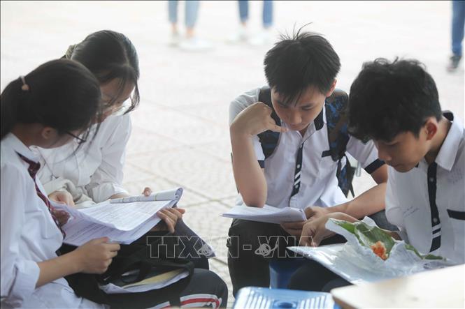 Trong ảnh: Thí sinh tranh thủ ôn lại kiến thức trước khi vào phòng thi. Ảnh: Thanh Tùng - TTXVN