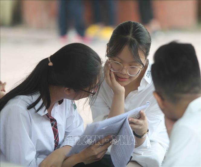 Trong ảnh: Thí sinh tranh thủ ôn lại kiến thức trước khi vào phòng thi. Ảnh: Thanh Tùng - TTXVN