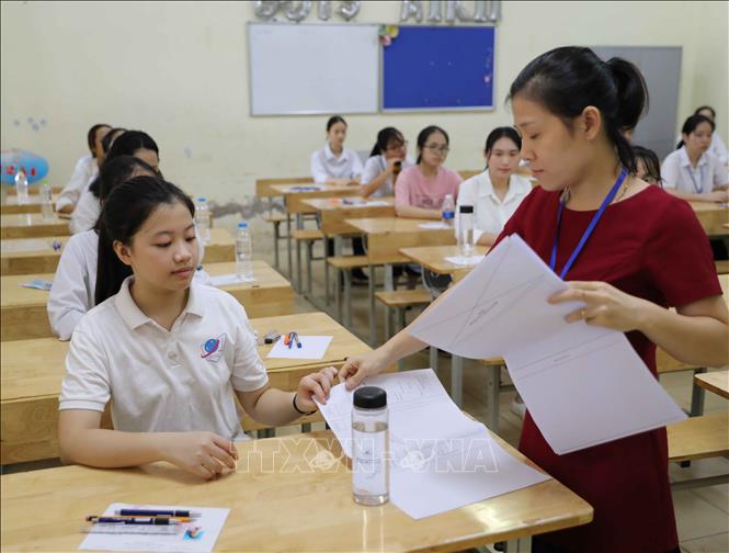 Trong ảnh: Giám thị phát giấy ghi cho thí sinh chuẩn bị làm bài môn Ngữ Văn. Ảnh: Thanh Tùng - TTXVN