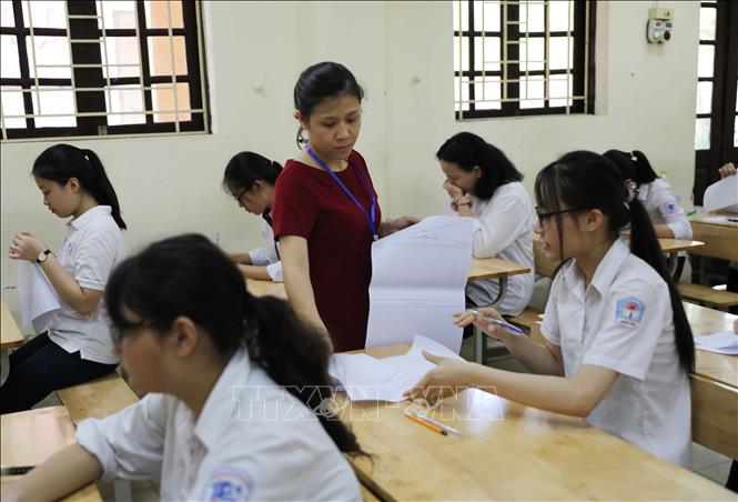 Trong ảnh: Giám thị phát giấy thi cho thí sinh chuẩn bị làm bài thi môn Ngữ Văn. Ảnh: Thanh Tùng - TTXVN