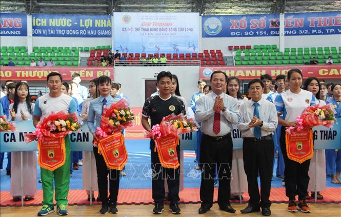 Trong ảnh: Các đoàn vận động viên nhận hoa và cờ lưu niệm từ Ban tổ chức. Ảnh: Hồng Thái - TTXVN