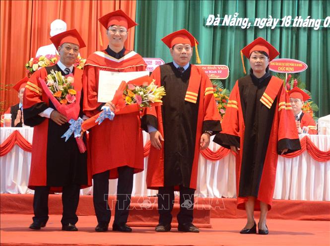 Trong ảnh: Đại diện trường Đại học Kinh tế (Đại học Đà Nẵng) trao bằng Tiến sĩ cho các sinh viên. Ảnh: Văn Dũng - TTXVN