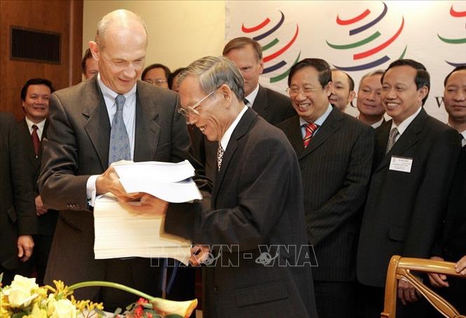 Với việc gia nhập ASEAN, lòng tin giữa Việt Nam với các nước láng giềng được nâng lên rõ rệt. Hội nhập của Việt Nam hiệu quả hơn, không chỉ là hội nhập khu vực mà là hội nhập thế giới, trong đó có bước ngoạt Việt Nam gia nhập Tổ chức Thương mại Thế giới (WTO). Trong ảnh: Trước sự chứng kiến của Phó Thủ tướng Phạm Gia Khiêm, Tổng Giám đốc WTO Pascal Lamy trao các văn kiện về việc kết nạp Việt Nam trở thành thành viên chính thức thứ 150 của WTO cho Bộ trưởng Thương mại Việt Nam Trương Đình Tuyển, tại buổi lễ kết nạp Việt Nam vào WTO, ngày 7/11/2006, tại trụ sở WTO ở Geneva (Thụy Sĩ). Ảnh: AFP/TTXVN phát