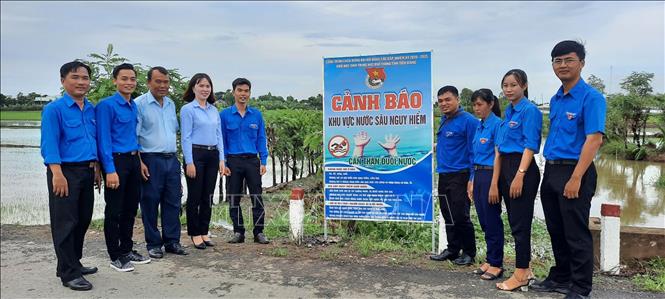 Trong ảnh: Gắn biển tuyên truyền, nâng cao nhận thức của người dân về công tác phòng, chống đuối nước cho trẻ em ở xã Phú Tân, huyện Tân Phú Đông. Ảnh: Hữu Chí-TTXVN