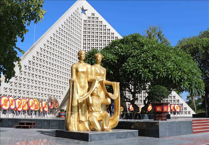 Trong ảnh: Cụm tượng màu vàng đặt bên trái nghĩa trang là hình tượng hai người phụ nữ dân tộc Thái, Kinh và em bé đang nâng dải lụa. Ảnh: Xuân Tiến-TTXVN