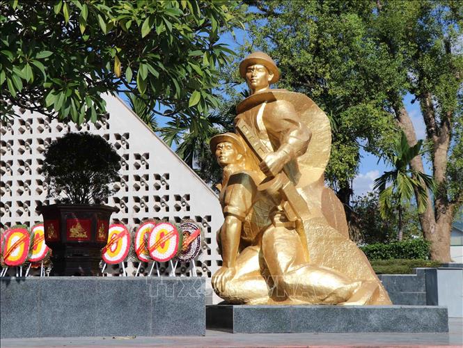 Trong ảnh: Cụm tượng màu vàng đặt bên phải nghĩa trang là hình tượng hai người lính mặc áo trấn thủ, đội mũ tai bèo. Ảnh: Xuân Tiến-TTXVN
