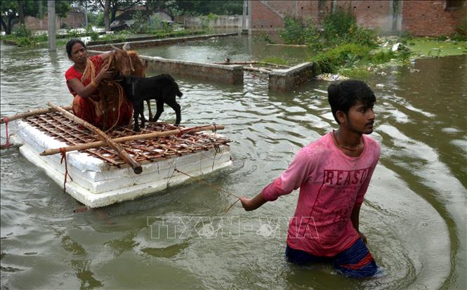 Trong ảnh: Người dân di chuyển qua khu vực ngập lụt sau mưa lớn tại Muzaffarpur, bang Bihar, Ấn Độ ngày 26/7/2020. Ảnh: THX/ TTXVN