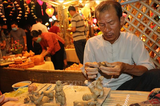 Trong ảnh: Nghệ nhân ở Thanh Hà (Quảng Nam) giới thiệu cách làm tò he. Ảnh: Chương Đài - TTXVN