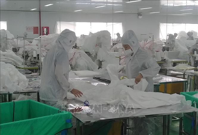 Trong ảnh: Công nhân nhà máy SanQi Việt Nam kiểm tra và đóng gói đồ bảo hộ y tế. Ảnh: Minh Hưng - TTXVN