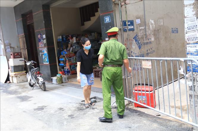 Trong ảnh: Lực lượng chức năng phong tỏa khu vực ngõ 230/26 Mễ Trì Thượng, nơi có trường hợp nghi nhiễm COVID-19 đang sinh sống. Ảnh: Lê Phú-TTXVN