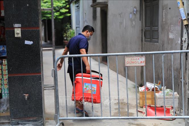 Trong ảnh:  Phong tỏa khu vực ngõ 230/26 Mễ Trì Thượng, nơi có trường hợp nghi nhiễm COVID-19 đang sinh sống để phun thuốc khử khuẩn. Ảnh: Lê Phú-TTXVN