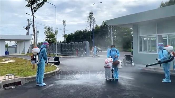 Trong ảnh: Phun khử khuẩn trước khi đưa công dân vào địa điểm cách ly tập trung tại Bình Dương. Ảnh: Dương Chí Tưởng - TTXVN 
