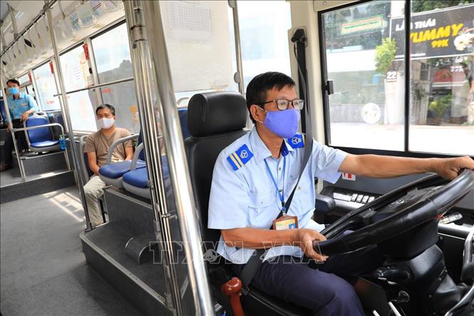Trong ảnh: Lái xe buýt thực hiện nghiêm việc đeo khẩu trang y tế khi đang làm việc. Ảnh: Thành Đạt - TTXVN 