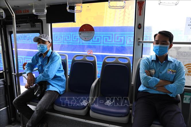 Trong ảnh: Các lái xe và phụ xe buýt thực hiện nghiêm việc đeo khẩu trang và khoảng cách giãn cách cần thiết. Ảnh: Thành Đạt - TTXVN 
