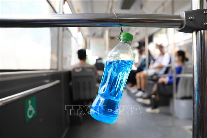 Trong ảnh: Trên mỗi xe buýt đều được trang bị chai chứa dung dịch sát khuẩn để khách rửa tay khi lên xe. Ảnh: Thành Đạt - TTXVN 
