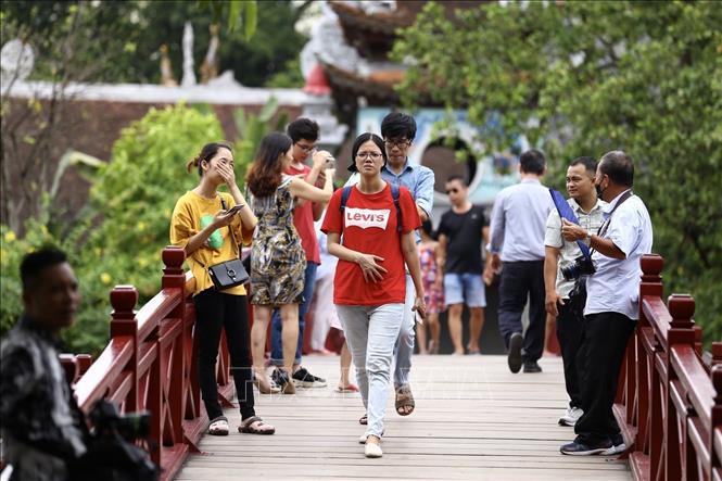 Trong ảnh: Nhiều thanh, thiếu niên vẫn chủ quan, không đeo khẩu trang nơi đông người ở khu vực cầu Thê Húc-đền Ngọc Sơn (ảnh chụp trưa 1/8). Ảnh: Minh Quyết - TTXVN