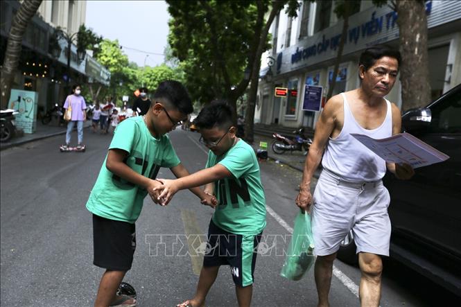 Trong ảnh: Nhiều trẻ em vẫn thản nhiên nô đùa, không đeo khẩu trang nơi đông người (ảnh chụp quanh phố đi bộ hồ Hoàn Kiếm, trưa 1/8). Ảnh: Minh Quyết - TTXVN