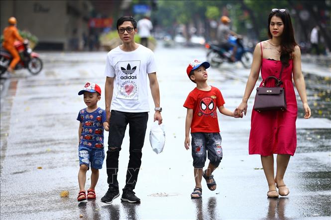 Trong ảnh: 4 người trong gia đình trẻ này vẫn thản nhiên đi dạo khu vực phố đi bộ hồ Hoàn Kiếm mà không đeo khẩu trang (ảnh chụp trưa 1/8). Ảnh: Minh Quyết - TTXVN