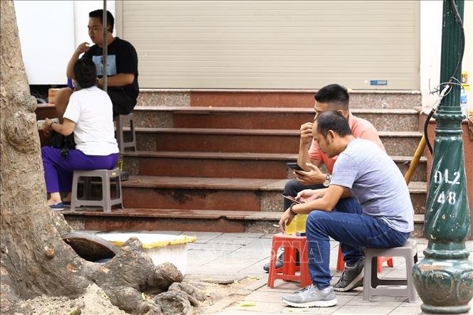 Trong ảnh: Nhiều quán nước vỉa hè vẫn hoạt động, bất chấp yêu cầu dừng hoạt động của Chủ tịch UBND Thành phố (ảnh chụp trưa 1/8). Ảnh: Minh Quyết - TTXVN