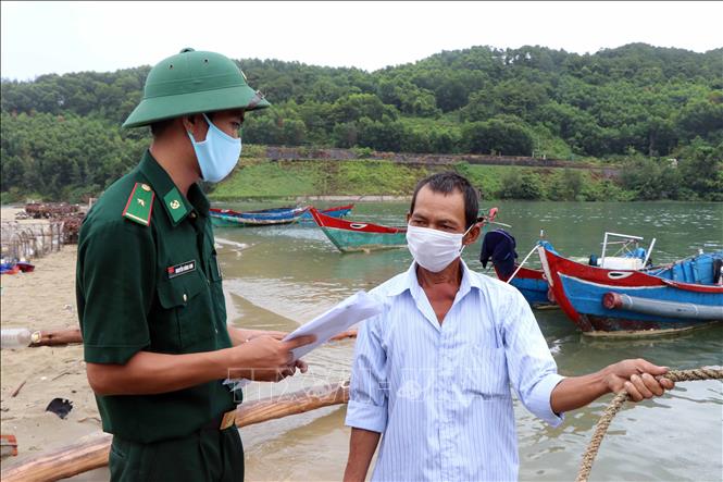 Trong ảnh: Cán bộ, chiến sĩ Đồn Biên phòng Lăng Cô tuyên truyền phòng chống dịch bệnh COVID-19 cho ngư dân ở thị trấn Lăng Cô, huyện Phú Lộc. Ảnh: Đỗ Trưởng - TTXVN