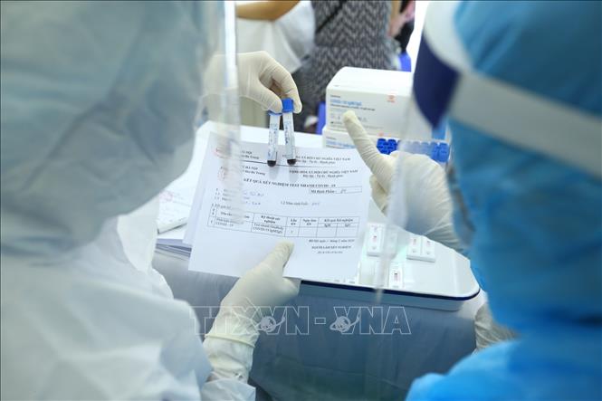 Trong ảnh: Nhân viên y tế lấy mẫu xét nghiệm nhanh cho người về từ Đà Nẵng, tại phường Bách Khoa và phường Cầu Dền (quận Hai Bà Trưng) sáng 01/8/2020. Ảnh: Minh Quyết - TTXVN