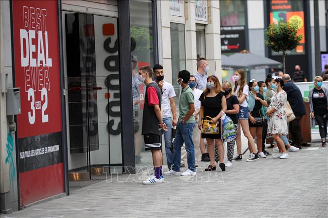 Trong ảnh: Người dân đeo khẩu trang phòng lây nhiễm COVID-19 khi xếp hàng bên ngoài một cửa hàng ở Brussels, Bỉ, ngày 1/8/2020. Ảnh: THX/ TTXVN