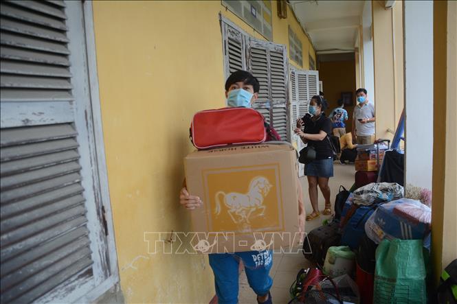 Trong ảnh: Sinh viên vận chuyển hành lý, vật dụng để nhường phòng cho công tác cách ly. Ảnh: Văn Dũng -TTXVN
