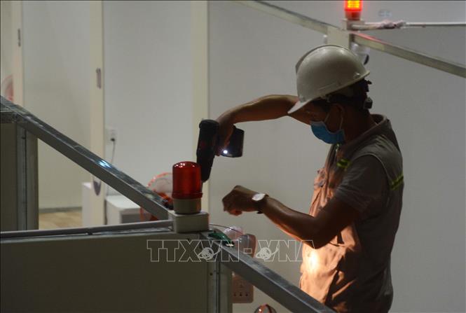 Trong ảnh: Công nhân đang khẩn trương hoàn thiện lắp đặt hệ thống đèn báo hiệu tại Bệnh viện dã chiến Cung Thể thao Tiên Sơn . Ảnh: Văn Dũng - TTXVN