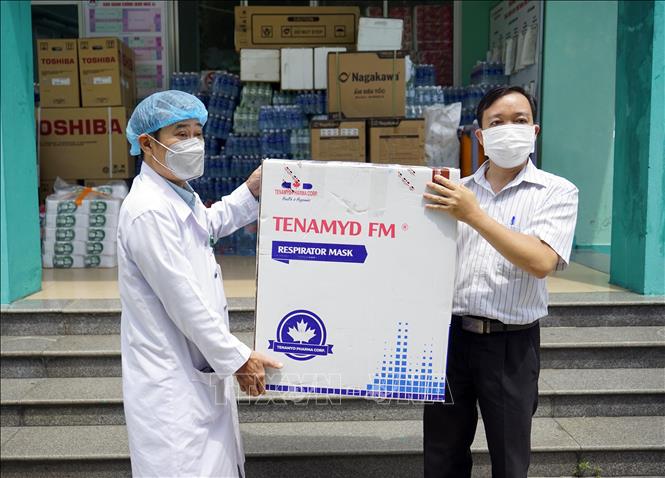 Trong ảnh: Đại diện trường Đại học Đông Á (bên phải) trao tặng các thùng khẩu trang N95 cho các cơ sở y tế tại Đà Nẵng. Ảnh: TTXVN phát 