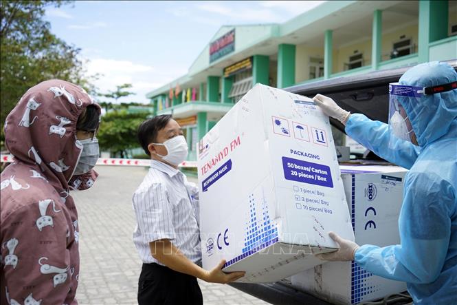 Trong ảnh: Đại diện trường Đại học Đông Á trao tặng các thùng khẩu trang N95 cho các cơ sở y tế tại Đà Nẵng. Ảnh: TTXVN phát 