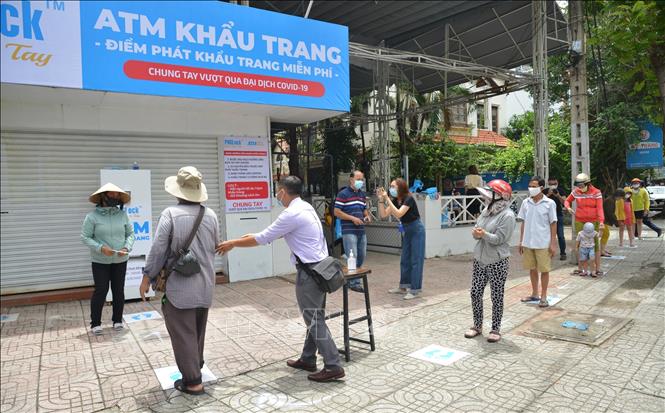 Photo: Locals line up to get their free face masks. VNA Photoo: Hứa Chung