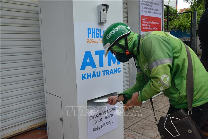 Photo: A Grabbike driver receives a free face mask. VNA Photo: Hứa Chung