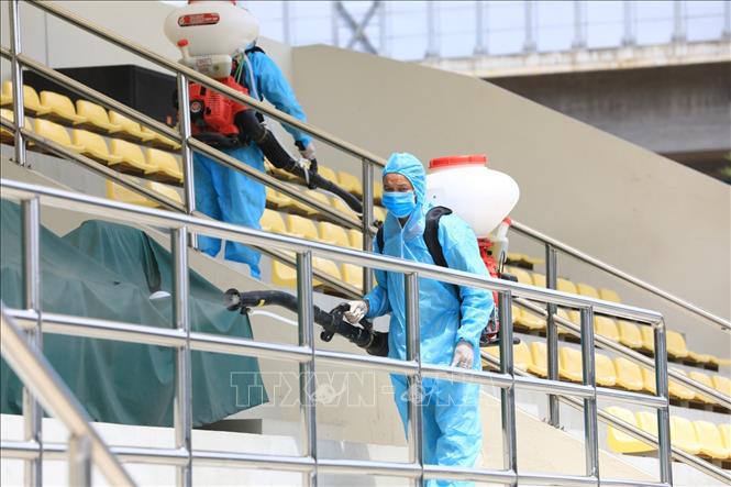 Trong ảnh: Nhân viên y tế quận Đống Đa phun thuốc khử trùng tại chỗ ngồi trước khi người dân đến lấy mẫu xét nghiệm. Ảnh: Thành Đạt - TTXVN 