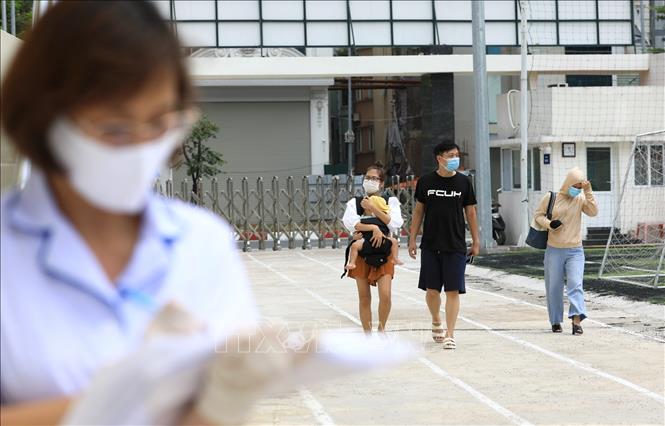 Trong ảnh: Từ sáng sớm, nhiều gia đình đã đến Trung tâm Văn hóa Thông tin và Thể Thao quận Đống Đa (237 Đặng Tiến Đông) - nơi xét nghiệm cho người dân quận Đống Đa trở về từ Đà Nẵng để được xét nghiệm RT-PCR. Ảnh: Thành Đạt - TTXVN
