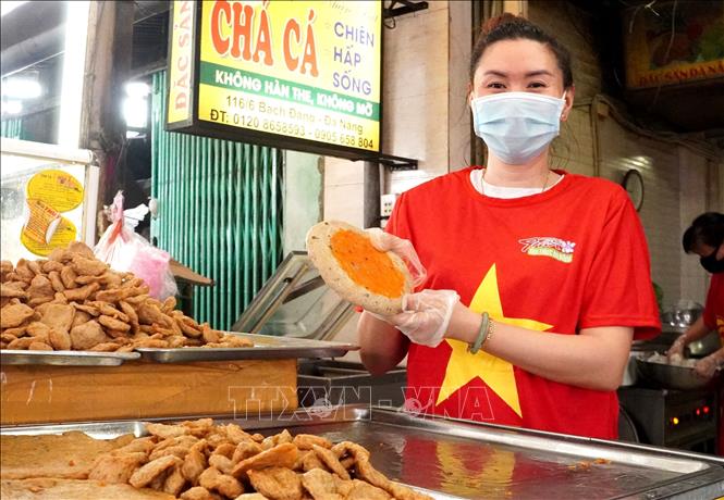 Photo:  Most of merchants in Da Nang city wear national flag t-shirts in the fight against COVID-19 pandemic. VNA Photo: Quốc Dũng