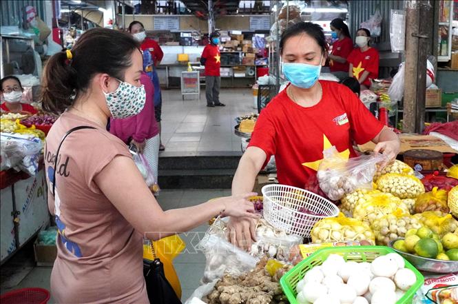 Photo:  Most of merchants in Da Nang city wear national flag t-shirts in the fight against COVID-19 pandemic. VNA Photo: Quốc Dũng