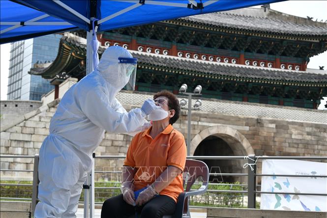 Trong ảnh: Nhân viên y tế lấy mẫu dịch xét nghiệm COVID-19 cho người dân gần chợ Namdaemun ở thủ đô Seoul, Hàn Quốc ngày 10/8/2020. Ảnh: AFP/TTXVN