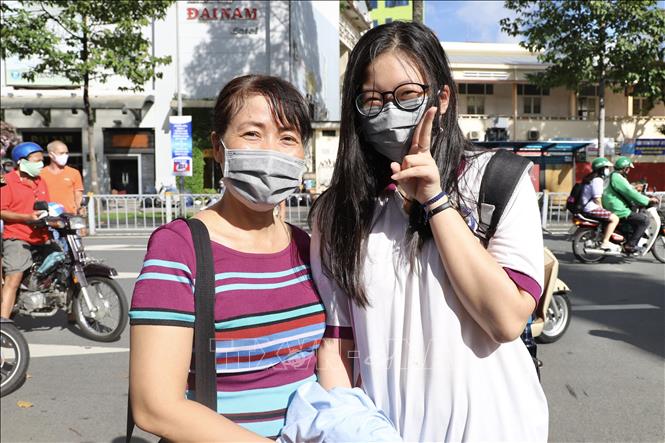 Trong ảnh: Một thí sinh vui vẻ khoe với mẹ mình làm bài tốt ở môn thi Tiếng Anh tại điểm thi Trường THPT Ernst Thalmann (Quận 1). Ảnh: Hồng Giang - TTXVN.