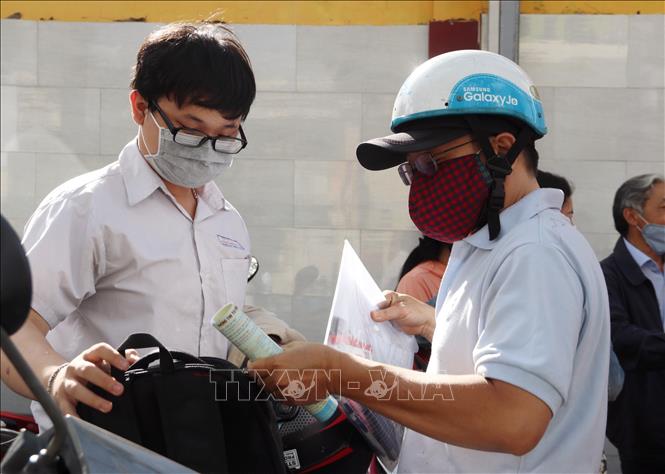 Trong ảnh: Phụ huynh đón thí sinh tại điểm thi Trường THPT Ernst Thalmann (Quận 1). Ảnh: Thu Hương - TTXVN.