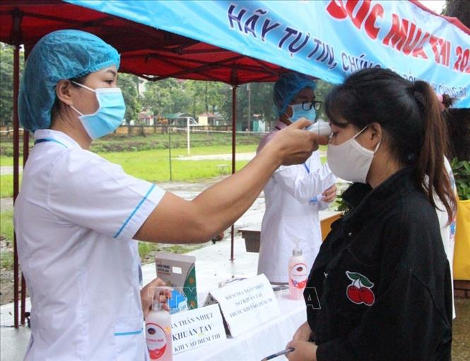 Trong ảnh: Thí sinh đo thân nhiệt trước khi vào phòng thi. Ảnh: Nguyễn Chiến.