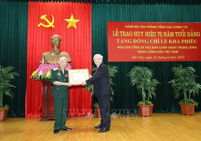 Trong ảnh: Tổng Bí thư, Chủ tịch nước Nguyễn Phú Trọng, Bí thư Quân ủy Trung ương trao tặng Huy hiệu 70 năm tuổi Đảng cho nguyên Tổng Bí thư Lê Khả Phiêu, sáng 25/8/2019, tại Hà Nội. Ảnh: Trí Dũng – TTXVN