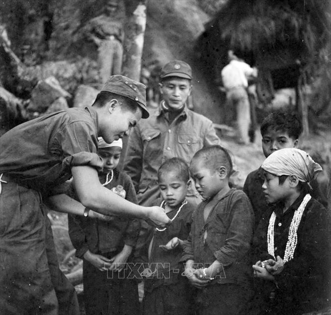 Trong ảnh: Chiến sĩ công an nhân dân vũ trang Đồn 235 phát thuốc cho trẻ em đồng bào dân tộc (1968). Ảnh: Vũ Tạo – TTXVN